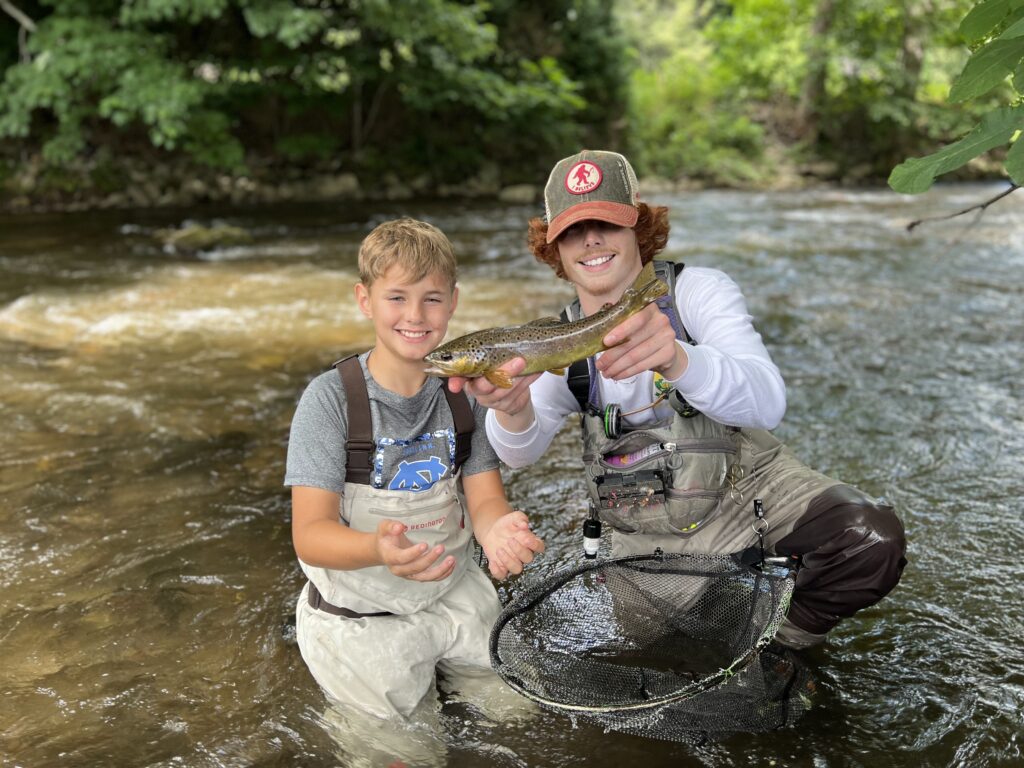 a kid showing off their first trout that they caught with Wild Water Fly Fishing