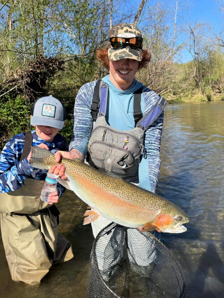 a young angler showing off a catch with Wild Water Fly Fishing owner Ryan Peck