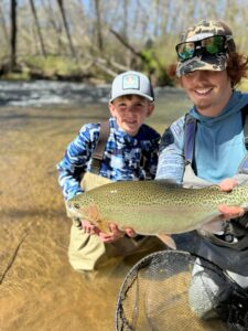 Ryan Peck and a young fishing student showing off a fish they caught