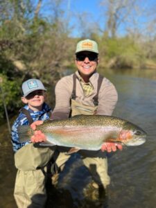 a father and son holding up a trout they caught on a Wild Water Fly Fishing guided fishing trip