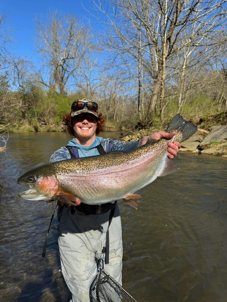 Ryan Peck, owner of Wild Water Fly Fishing, holding up a huge trout he caught on a guided fishing trip