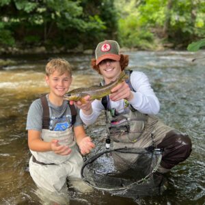 Ryan Peck and a young angler holding up a catch on the river